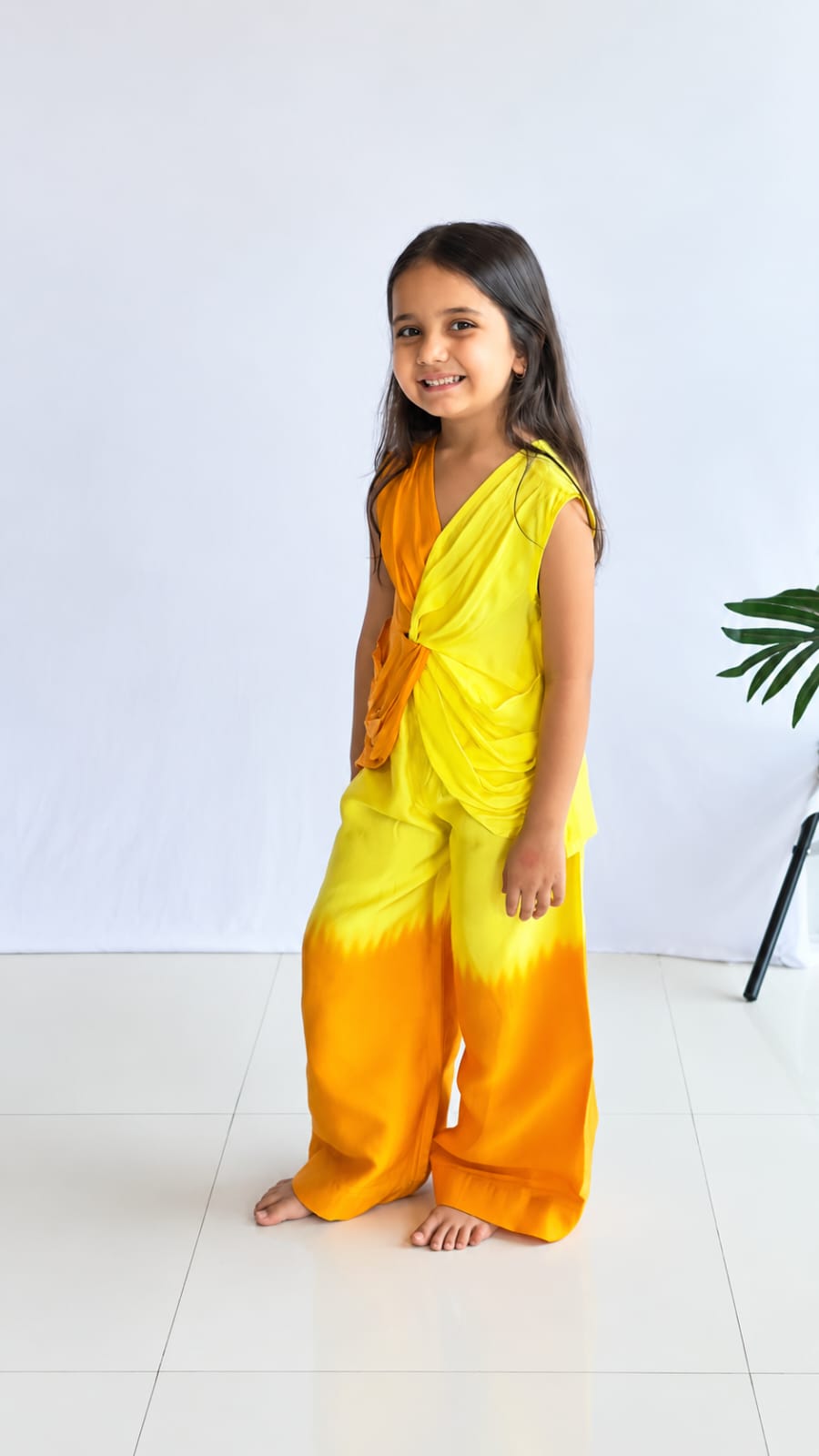 Girl wearing yellow and orange ombre drape top with wide-leg palazzo pants