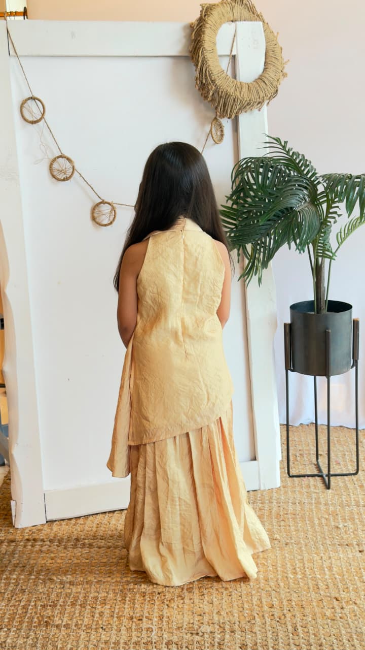 Side view of a girl modelling a golden kurta sharara set with dupatta