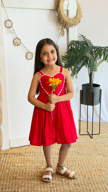 Girl wearing a red sleeveless fit-and-flare dress with heart detail