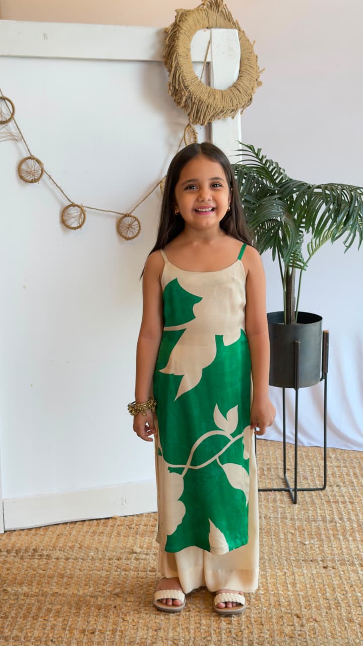 Back view of a girl wearing an emerald green and cream tunic set with palazzo pants