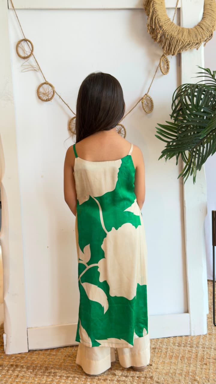 Girl wearing an emerald green and cream botanical print tunic with cream palazzo pants