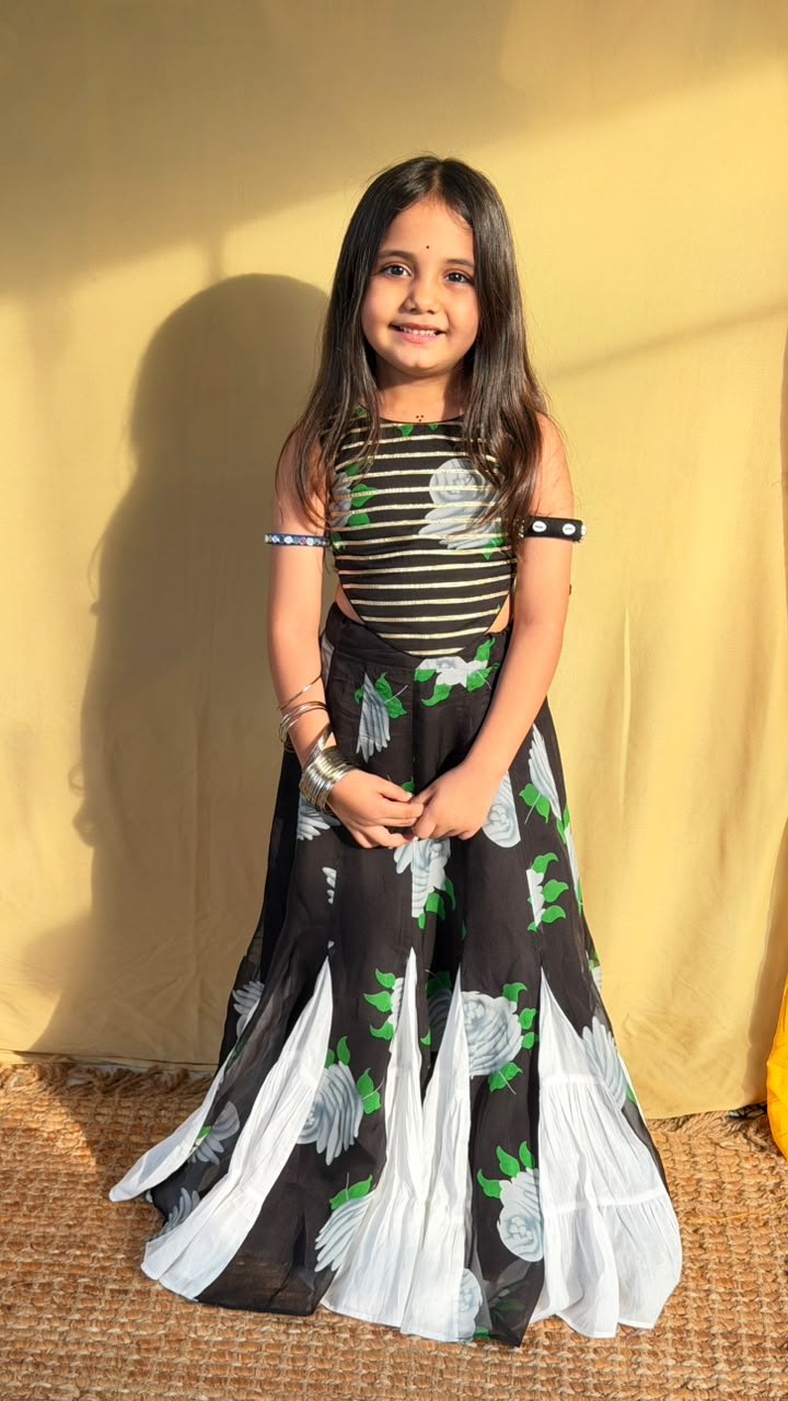 Side view of the black floral girls’ lehenga set showing the flared skirt and contrasting white panels