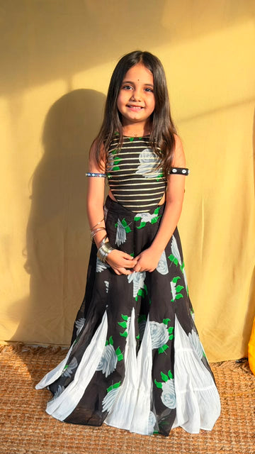 Side view of the black floral girls’ lehenga set showing the flared skirt and contrasting white panels