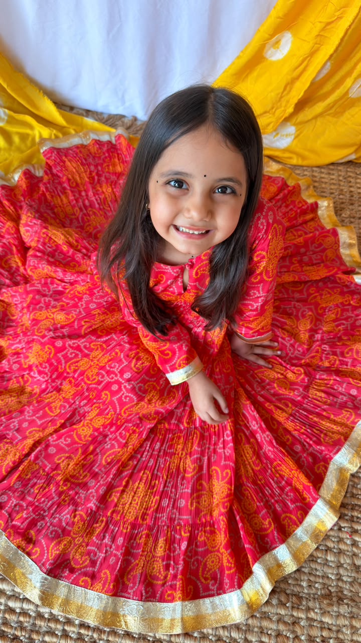 Close view of the red printed Anarkali dress showing its full gathered skirt and gold-toned hem trim